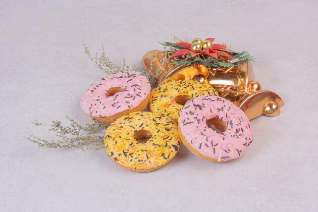 粉色白色表面有四个五颜六色的甜甜圈甜点美味甜甜圈