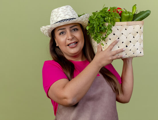 帽子围裙戴帽子的中年园丁妇女拿着装满蔬菜的板条箱板条箱脸女人