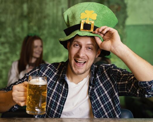 饮料戴帽子庆祝圣帕特里克节的快乐男人的正面图活动三叶草圣帕特里克日