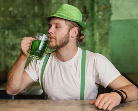 帽子用酒庆祝圣帕特里克节的人派对绿色品脱