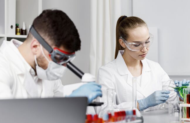 创新戴着手套和试管的女研究员在实验室里水平技术员专家