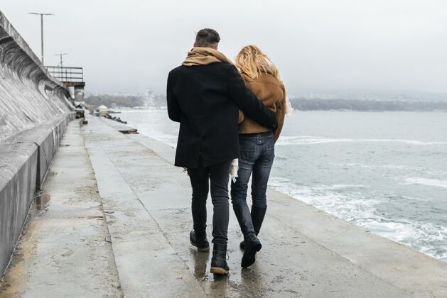 水平冬天 一对情侣在沙滩上散步的背影户外休闲旅行