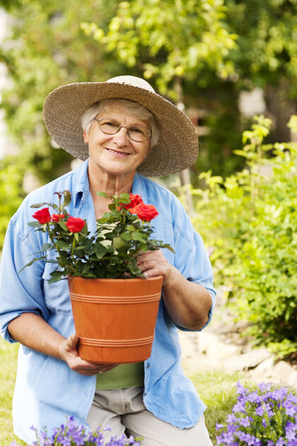 花盆花园里拿着花的老妇人成人农场幸福