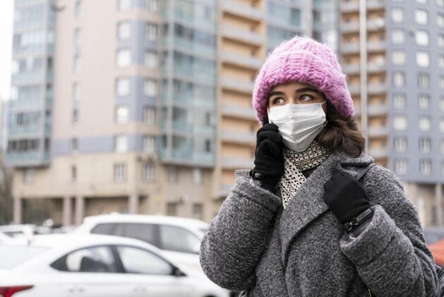 病毒戴着医用口罩的女人在城里打电话防护安全公民