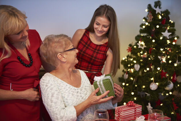 礼物一个十几岁的女孩给她的祖母一个礼物站立债券圣诞树