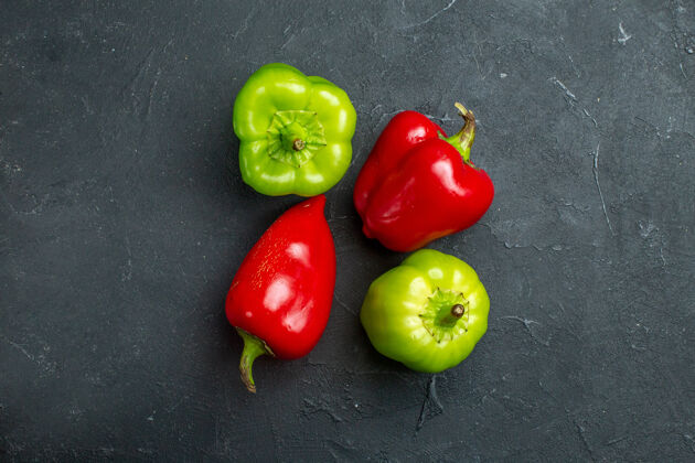 生的顶视图绿色和红色辣椒在黑暗的表面自由空间有机青椒胡椒