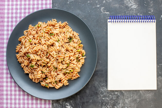 谷物顶视图圆盘子上的意大利面 粉白色格子桌布 黑色表面上的记事本 食物照片豆类格子风景