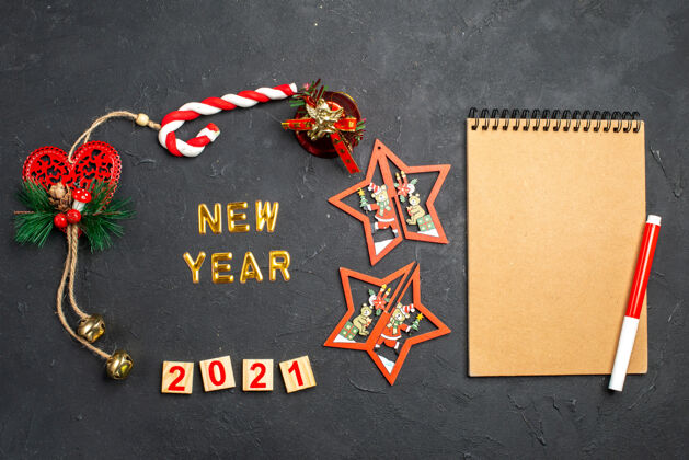 粉笔俯瞰新年在一圈不同的圣诞饰品和红色记号笔上的笔记本上暗隔绝的表面黑板粉笔装饰品