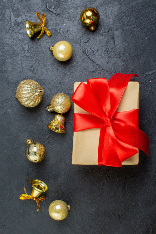 礼品盒黑色桌子上带有红丝带和装饰配件的礼品盒的垂直视图圣诞节头发幻灯片视图
