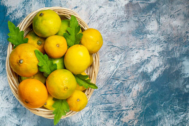 苹果顶视图新鲜的柑桔在柳条篮子上蓝白色的表面复制的地方柠檬篮子水果