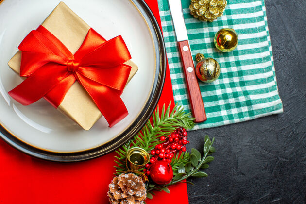 空盘子国家圣诞大餐背景俯视图 空盘子上有蝴蝶结形状的红丝带 餐具套装 绿色条状毛巾上有装饰配件毛巾民族长条
