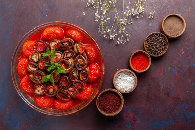 茄子俯瞰烹饪蔬菜餐美味的西红柿和茄子与调味品在黑暗的表面烹饪硬币调味品