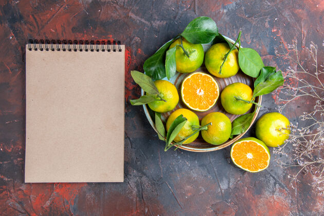 苹果顶视图新鲜的柑橘在碗里一个笔记本上暗红色的表面新鲜的普通话碗水果
