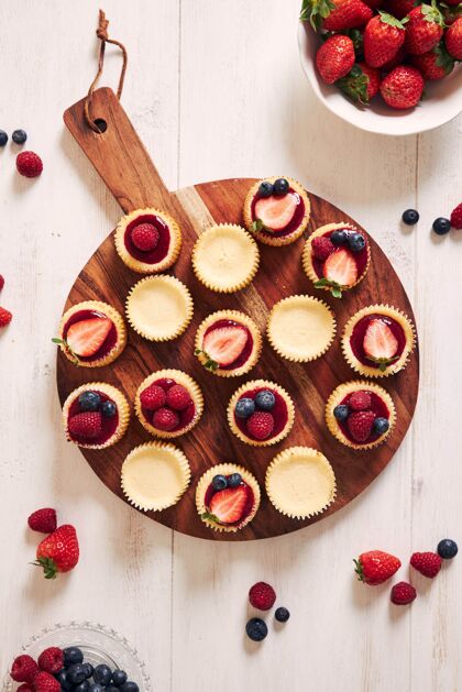 顶视图木盘上有水果果冻和水果的芝士纸杯蛋糕糕点治疗美丽