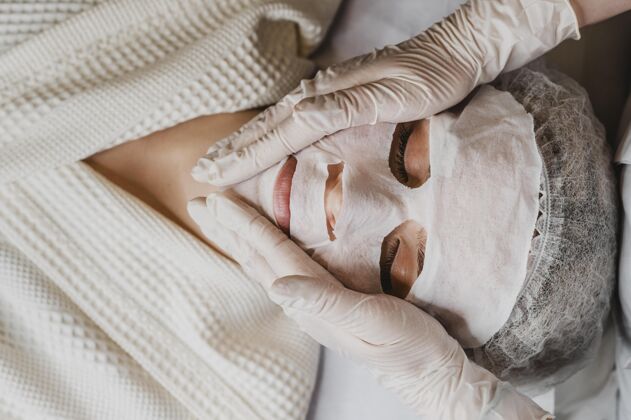 健康年轻女子接受皮肤面膜治疗的顶视图皮肤护理女人过程
