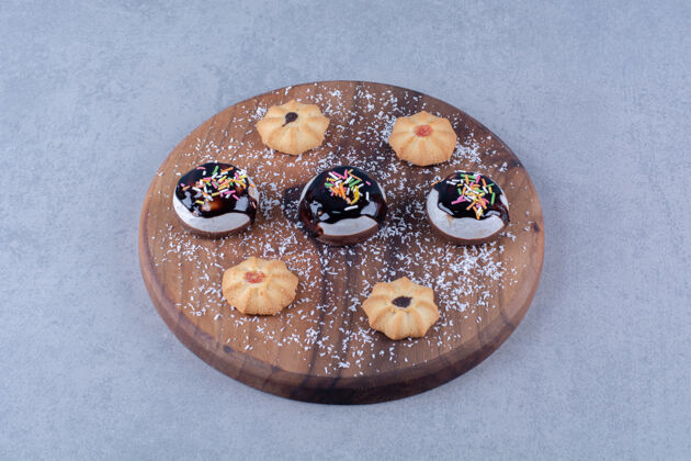 木板一块木板 上面放着不同的甜饼干和巧克力糖浆好吃的食物甜点
