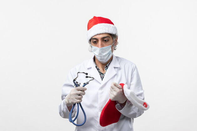 视图正面图男医生手持节日袜白墙病毒共价节日健康圣诞节医院实验室外套