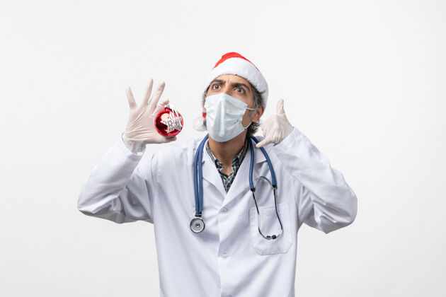 医药正面图男医生戴着口罩和玩具上白墙健康病毒共度新年视图圣诞节病毒