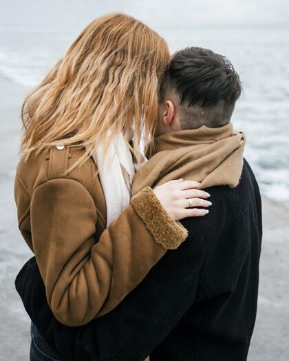 探险年轻情侣在外面冬天接吻的侧视图户外消遣冬天