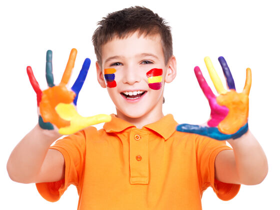 游戏在白色的墙上 一个快乐的微笑着的男孩 他的手和脸都涂上了橘色的t恤微笑快乐快乐