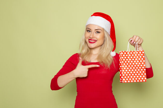 成人前景靓女抱着礼物在绿墙小包装上节日圣诞雪彩新年感慨包装漂亮的女人颜色
