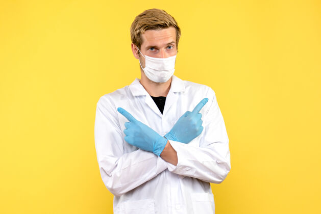 肖像正面图黄色背景上戴面罩的男医生-健康大流行医生衣服正面男性