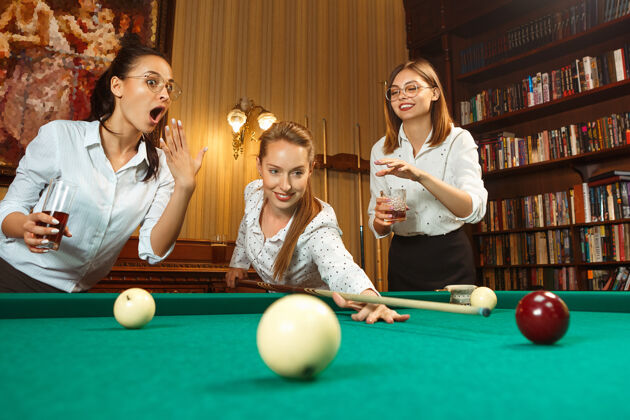 团体下班后在办公室或家里打台球的微笑的年轻女性酒吧玩活动