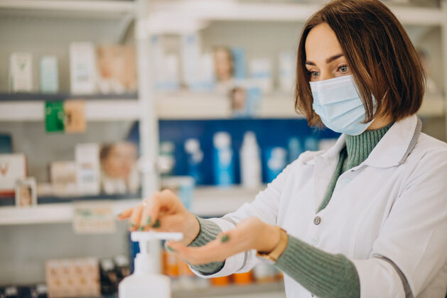 服务年轻的女药剂师用消毒剂洗手零售处方清洁