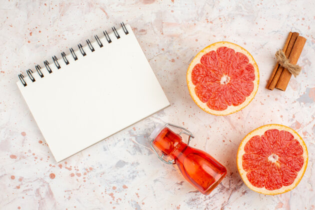 维生素俯视图切割柚子肉桂棒瓶一个笔记本在裸体表面切片新鲜甜瓜