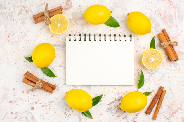 柠檬俯视新鲜柠檬在一个圆形切割柠檬肉桂棒笔记本上明亮的孤立表面圆圈顶部视图