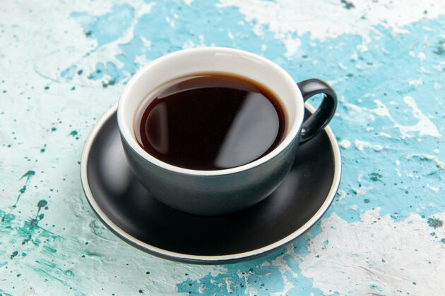 混合饮料正面图蓝色表面上的茶杯和盘子内的热饮咖啡潘趣酒里面