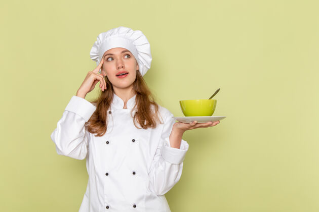 厨房身穿白色厨师服的女厨师正拿着绿色盘子 绿色墙上摆着盘子淋浴封面女厨师