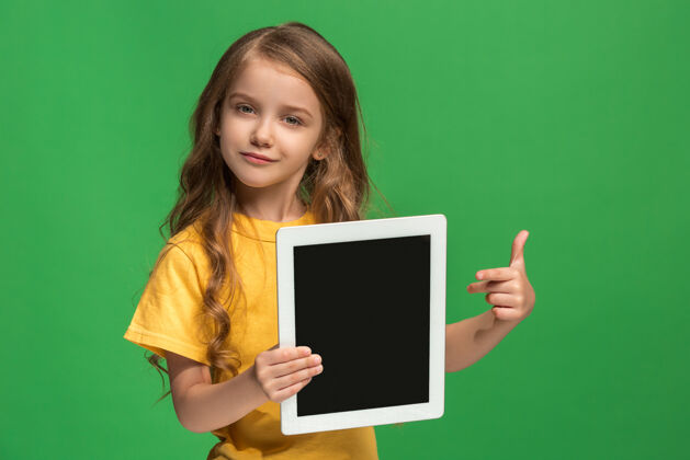 可爱在绿色工作室里有一个有趣的小女孩学生童年电脑
