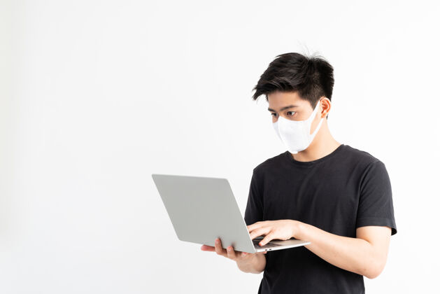 男孩亚洲男子戴口罩保护冠状病毒冠状病毒冠状病毒19日使用笔记本电脑在检疫室 检疫自己 以保护传播冠状病毒19独处传播使用电脑