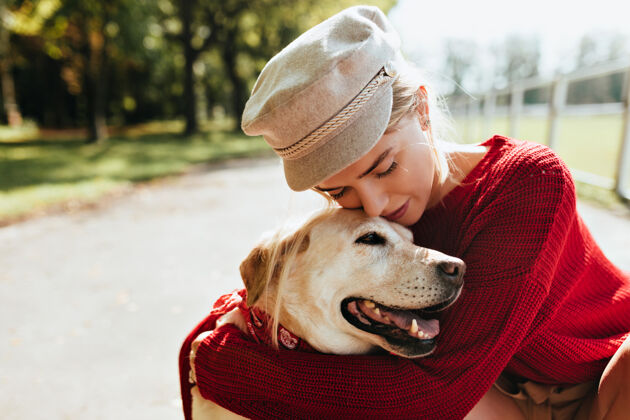 散步美丽的金发女郎和她心爱的狗一起在户外度过秋天一个年轻女子和她的宠物在公园美丽的肖像快乐哺乳动物狗