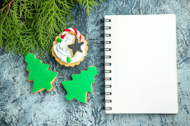 树圣诞树饼干记事本在灰色的桌子上旧的圣诞节卡片