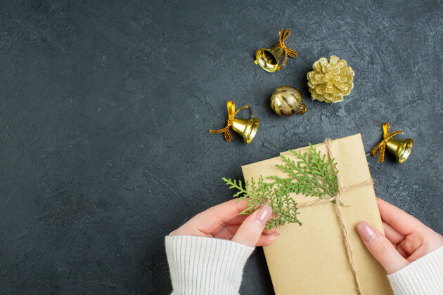 扣件上图为黑色背景上的手持礼品盒和装饰配件圣诞节景观礼品盒
