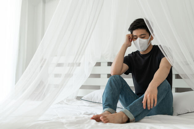 卫生亚洲男子戴口罩以防在检疫室因冠状病毒冠状病毒-19而感到头痛和咳嗽痛苦面具亚洲人