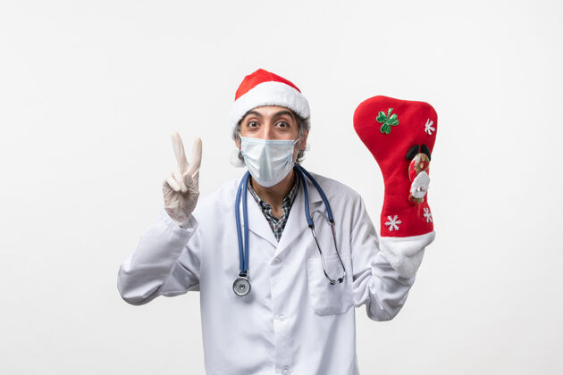 大正面图白色墙壁上戴着大红袜子的男医生病毒冠状病毒-圣诞节病毒袜子外套