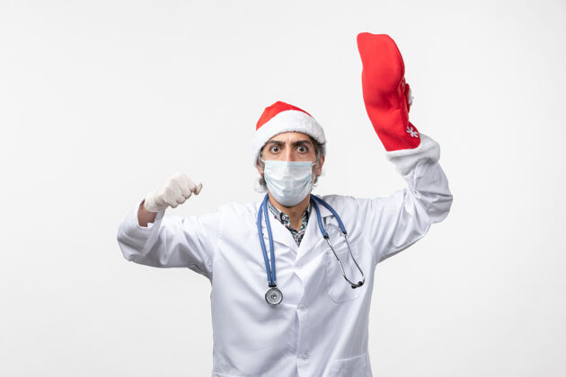 圣诞节正面图白色办公桌上戴着大红袜子的男医生-圣诞假期男人冠状病毒大
