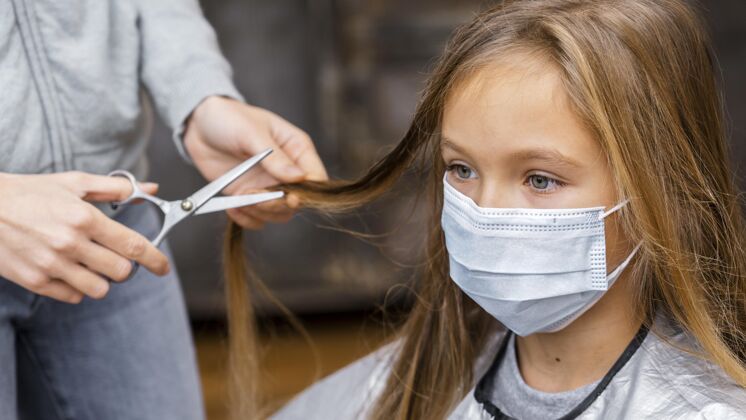 剪刀在理发店戴着医用口罩的女孩美容院女孩沙龙