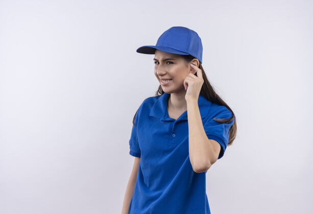恼火穿着蓝色制服 戴着帽子的年轻女送货员带着恼怒的表情用手指捂住耳朵手指耳朵年轻