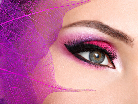 睫毛用漂亮时尚的亮粉色妆容特写女性眼睛颜色化妆睫毛