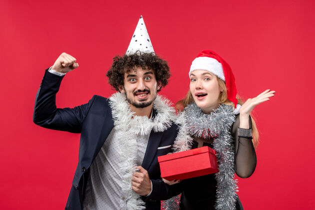 肖像红墙圣诞爱情派对彩色新年礼物的年轻夫妇的正面图服装色彩风景