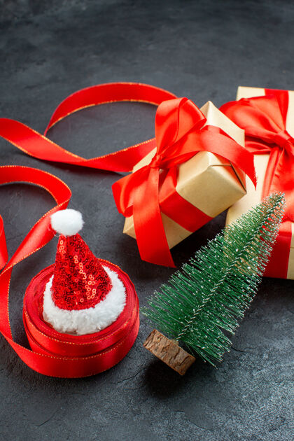 顶顶上看美丽的礼物与红丝带和圣诞树圣诞老人帽子在一个黑暗的桌子上轮子圣诞节圣诞老人