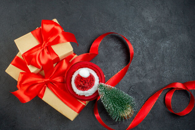风景俯瞰美丽的礼物与红丝带和圣诞老人帽圣诞树在黑暗的桌子上帽子圣诞老人轮子