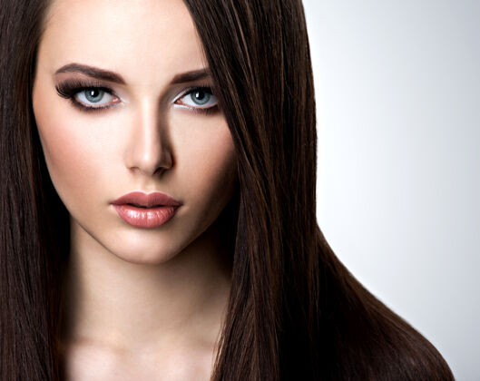 棕色在摄影棚 一位留着长直发的年轻漂亮女子的肖像黑发华丽漂亮