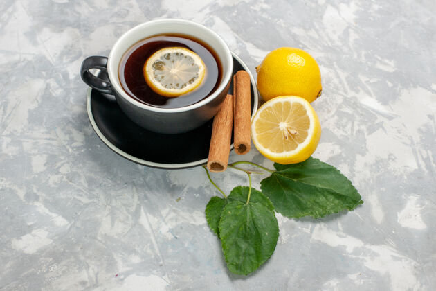 饮料正面是一杯茶 白色表面有肉桂和柠檬柠檬水果可食用的水果
