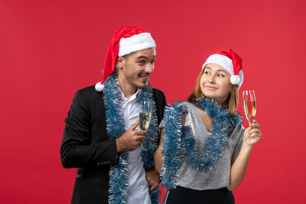风景前视图年轻夫妇在红墙爱心圣诞派对上庆祝新年快乐美丽微笑