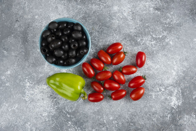 碗黑橄榄 胡椒和番茄放在大理石上观点胡椒橄榄